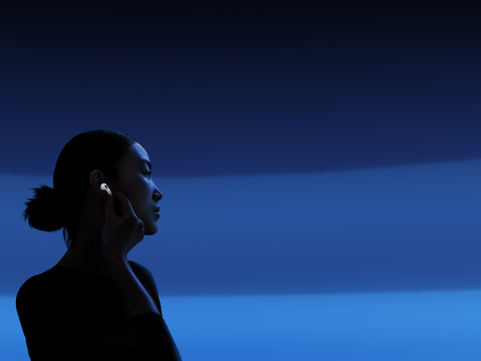 Une personne tenant la tige de ses AirPods 5 entre le pouce et l'index pour changer les modes d'écoute