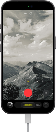 iPhone 18 Pro, face avant, affichant un paysage montagneux, avec le mode caméra incrusté en mode Accéléré, avec câble d'alimentation branché sur le port de charge