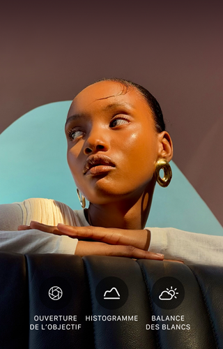 Portrait lumineux en gros plan d'une personne sur un fond coloré, illustrant l'interface des commandes Pro du système caméra pro : ouverture, histogramme, balance des blancs