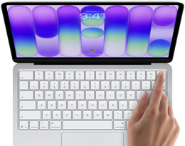 MacBook Neo, couleur argent, affichant l'écran de connexion, doigt d'une personne sur le capteur Touch ID situé dans le coin supérieur droit du clavier